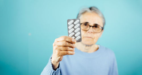 Midsection of woman holding key against blue background