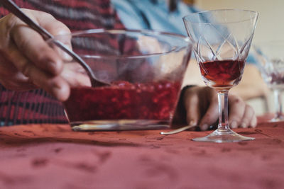 Midsection of man drinking wine at restaurant