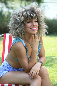 Portrait of smiling young woman sitting outdoors