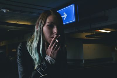 Close-up of young woman smoking at home