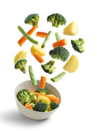 Boiled vegetables flying on white background. creative concept