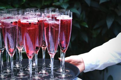 Cropped image of waiter carrying champagne glasses in tray