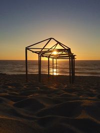 Beachtent frame on beach against clear sky during sunset