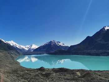 Scenic view of snowcapped mountains against clear blue sky