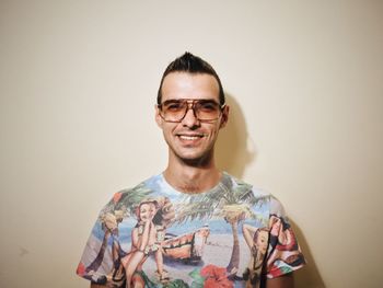 Smiling young man standing against wall