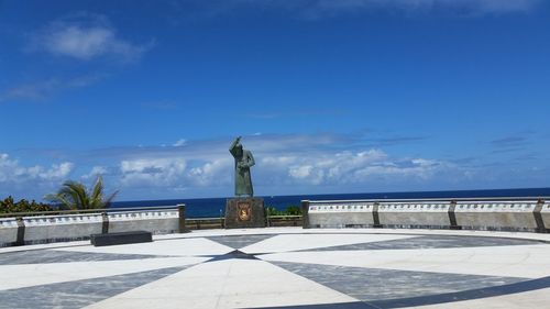 Statue by sea against sky