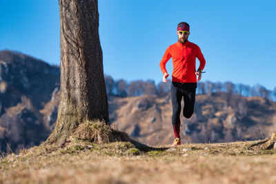 Full length of man running on plant against sky