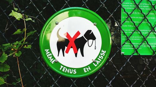 Close up of no dogs allowed sign on chainlink fence