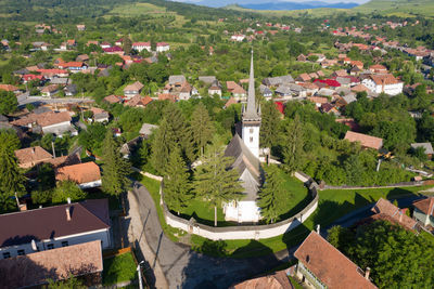 Aerial drone point of view of a whitewashed protestant church in manastireni, transylvania, romania