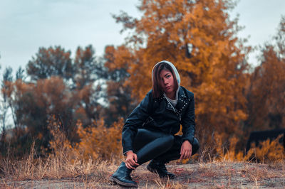 Full length of senior man sitting on road