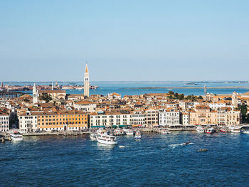 Scenic view of sea and buildings against clear sky