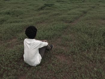 Rear view of girl sitting on grass