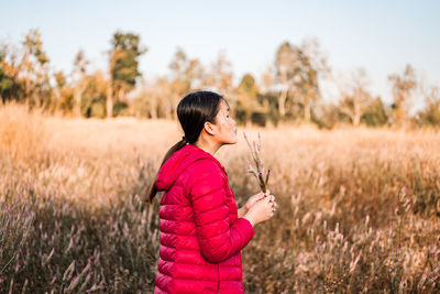 Side view of woman standing on field