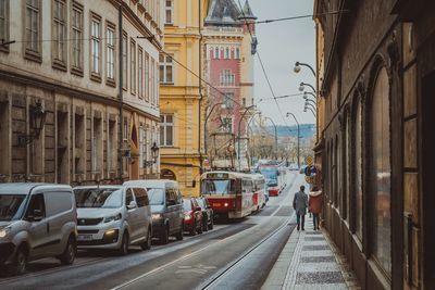 Cars on street in city against sky