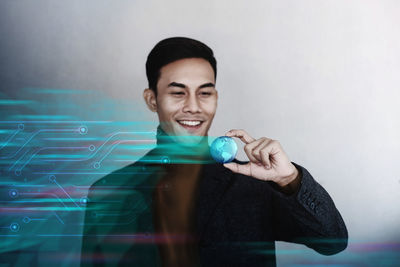 Portrait of a smiling young man holding camera