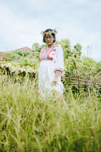 Woman standing on field against sky