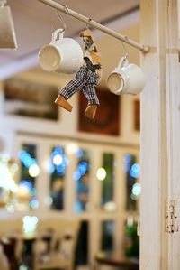 Low angle view of coffee cup with stuffed toy hanging on pole