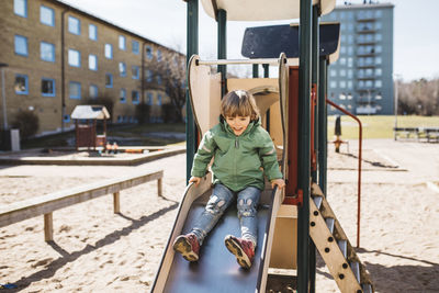 Boy sitting on top of slide