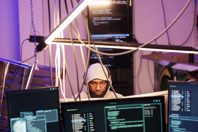 Portrait of young man using laptop at airport