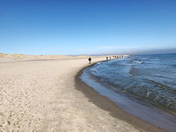 Scenic view of beach against clear blue sky