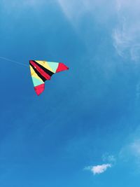 Low angle view of kite flying in blue sky