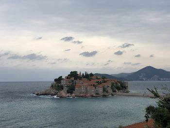 Scenic view of sea by buildings against sky