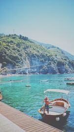 Boats moored on sea against clear sky