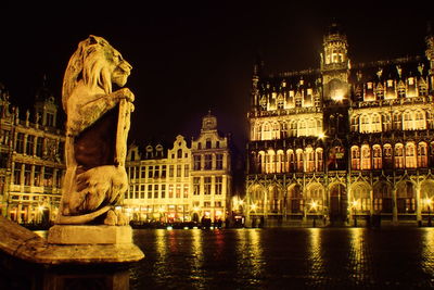 Statue in city at night