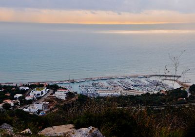 High angle view of townscape by sea against sky