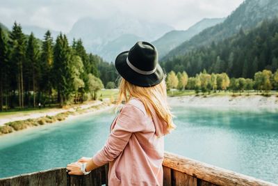 Rear view of woman standing against lake