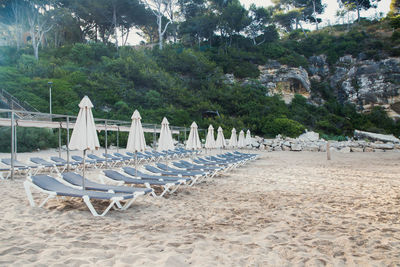 Scenic view to a chaise lounges and umbrellas on the sandy beach without people