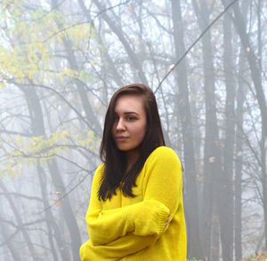 Young woman standing in forest