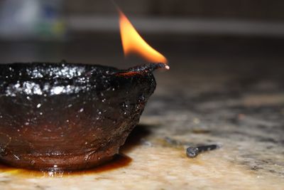 Close-up of burning candle on wood