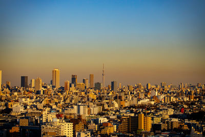 Modern buildings in tokyo city against sky during sunset