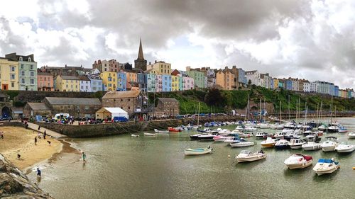 Panoramic view of town by river against sky