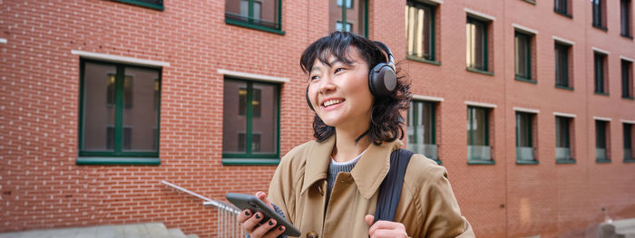 Young woman using mobile phone in city