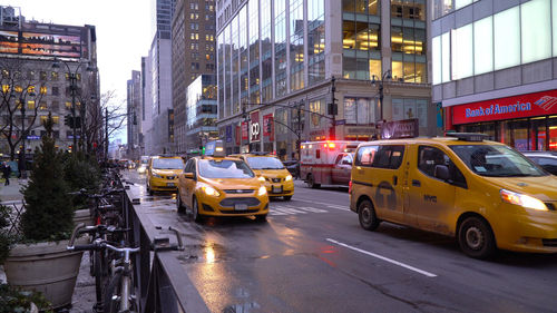 Traffic on road by buildings in city