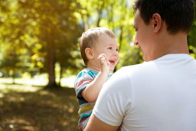 Dad plays with his little son in the park outdoors. family time. happy smiling people.