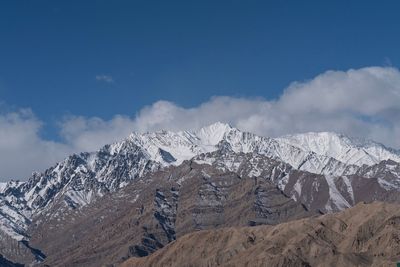 Scenic view of snowcapped mountains against blue sky