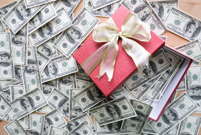 High angle view of gift box with paper currencies on table