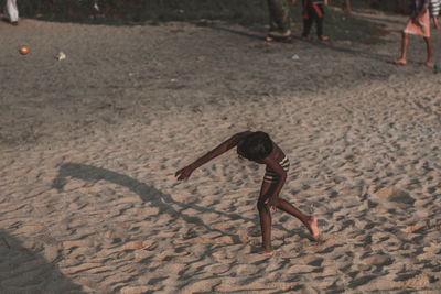 Shirtless boy running at beach