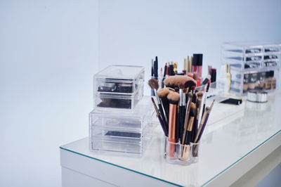 Close-up of paintbrushes on table against white background