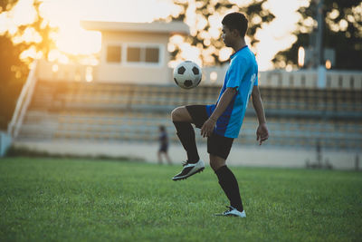 Full length of woman playing soccer on field