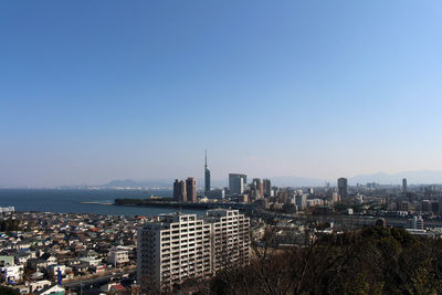 Modern buildings in city against clear blue sky