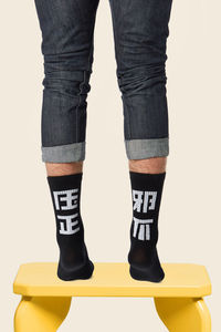 Low section of man standing against white background