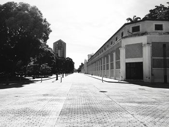 Empty street amidst buildings in city against sky