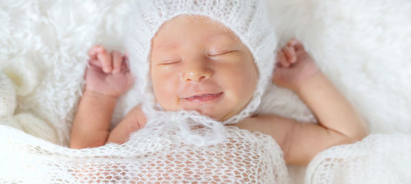 Smiling cute baby girl sleeping on bed