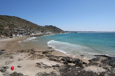 Scenic view of beach against clear blue sky