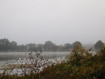 Scenic view of lake against sky during foggy weather