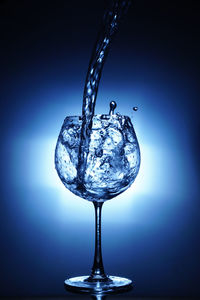 Close-up of wine glass against blue background